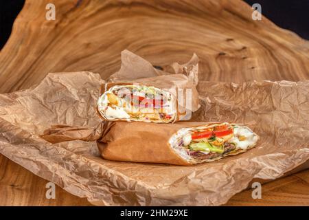Köstlicher saftiger Shawarma auf einem Holztisch Stockfoto