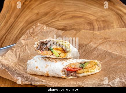 Köstlicher saftiger Shawarma auf einem Holztisch Stockfoto