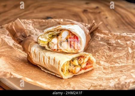 Köstlicher saftiger Shawarma auf einem Holztisch Stockfoto