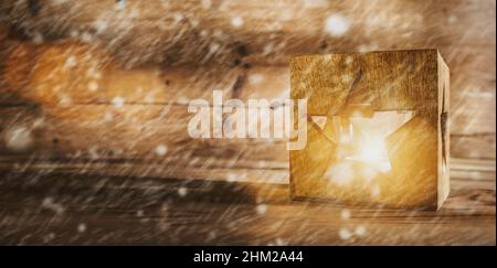 Weihnachtshintergrund mit einer leuchtenden Stern Symbol Laterne, Holzbrett und Schnee Hintergrund Stockfoto