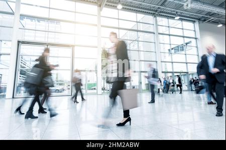 Geschäftsleute, die auf einer Messetage stehen und gehen Stockfoto