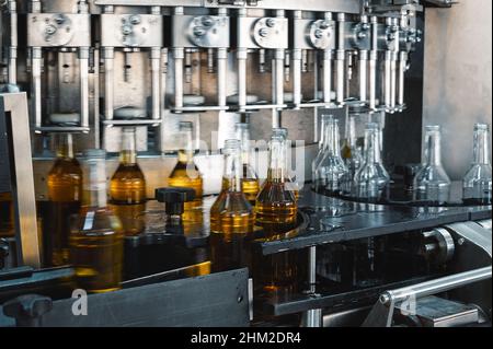 Die automatische Ausrüstung bringt Verschlüsse auf Flaschen mit alkoholischen Getränken Stockfoto