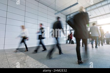 Geschäftsleute, die im Korridor der Messe spazieren Stockfoto