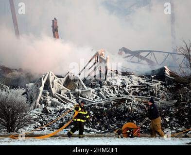 Bartlett, IL, USA. 6th. Februar 2022. 6. Februar 2022 Bartlett, Illinois, USA: Feuerwehrleute arbeiten am Schauplatz eines massiven Lagerfeuers, während Trümmer für einen vierten Tag weiter brannten Sonntag, den 6. Februar 2022. Feuerwehrleute verwenden etwa 2.000 Gallonen Wasser pro Minute, um die schwelenden Trümmer zu entwässern. Das 250.000 Quadratmeter große Lager, das von einem Dokumentenlagerunternehmen namens Access genutzt wird, stellt einen Totalschaden dar. Kredit: ZUMA Press, Inc./Alamy Live Nachrichten Stockfoto