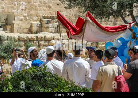 Die Teilnehmer einer jüdischen Bar-Mitzwa-Feier tragen eine Chuppah in der Nähe der Mauern des Tempelbergs in Jerusalem, Israel, 2016 Stockfoto