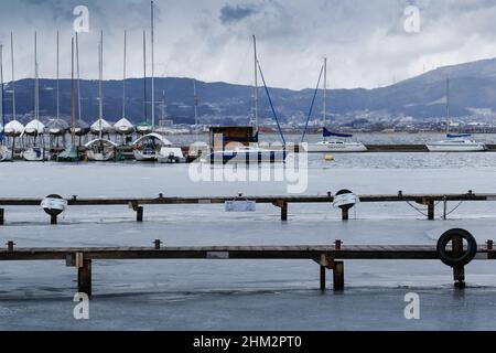 suwa, nagano, japan, 2022/06/02 , Blick auf den gefrorenen See Suwa (Suwa-ko) vom See Suwa Yacht Hafen. Der Suwa-See ist ein See in den Kiso-Bergen, ich Stockfoto