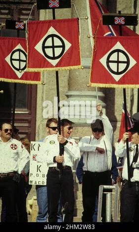 Austin Texas USA, 1989: Weiße supremazistische Mitglieder des Ku Klux Klan tragen während der Kundgebung vor dem Texas Capitol auf Hechten arische Symbole. ©Bob Daemmrich Stockfoto