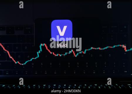 Rottweil, Deutschland. 06th. Februar 2022. Das Logo von Vivid spiegelt sich in einem Display eines MacBook wider, wobei auf dem Monitor ein Candlestick-Chart einer Kryptowährung zu sehen ist. Die Berliner Smartphone-Bank Vivid nähert sich nach einer Finanzierungsrunde einer Milliardenbewertung. Kunden können ihr Geld auch in Aktien, Fonds, Kryptowährungen und andere Finanzprodukte in der Vivid App investieren. Kredit: Silas Stein/dpa/Alamy Live Nachrichten Stockfoto