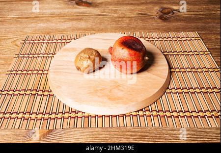 Verwöhnter Granatapfel und Kiwifruit auf einem runden Schneidebrett Stockfoto