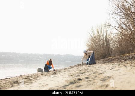 Zwei Ökologinnen säubern das Ufer von Kunststoffen Stockfoto