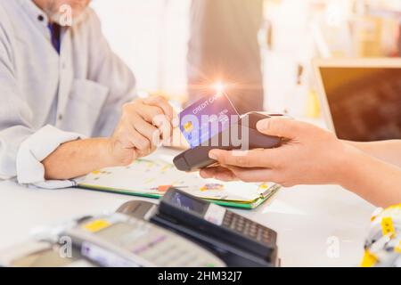 Kunden, die das Zahlungssystem für Kreditkartenzahlungen zum Kauf von Produkten verwenden. Stockfoto