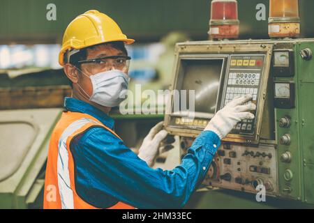 Asiatische Arbeiter tragen Einweg-Gesichtsmaske zum Schutz Corona Virus Verteilung und Rauchstaub Luftverschmutzung Filter in der Fabrik für gesunde. Stockfoto