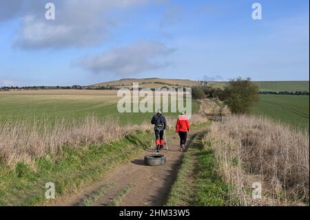 VEW of White Horse Hill vom Ridgeway aus eine alte Route über die Downs im Süden von Oxfordshire. Ein Mann, der für eine Polarexpedition trainiert, geht entlang der Strecke Stockfoto