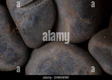 Schwarze runde Kopfsteinpflaster-Stein-Textur für Tapete und Hintergrund. Abstrakter Hintergrund. Texturhintergrund. Makrofotografie. Nahaufnahme. Stockfoto
