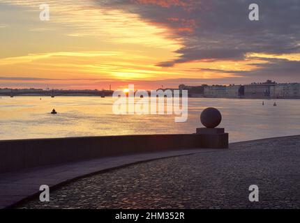 Sonnenaufgang über dem Fluss Neva. Blick auf die Dreifaltigkeitsbrücke und den Palastdamm vom Spieß der Insel Vasilievsky. Granitbrüstchen mit einem Steinbauch Stockfoto