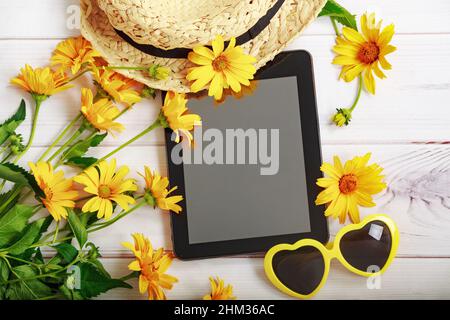 Sommermuster mit gelben Gänseblümchen, Strohhut, Tablett und Brille in Herzform. Stockfoto