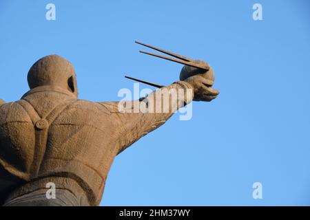 Eine Bronze-Metallstatue eines stehenden Juri Gagarin, des ersten russischen Mannes im Weltraum. Er hält ein Modell des Sputnik-Satelliten. In Taschkent, Usbekistan Stockfoto