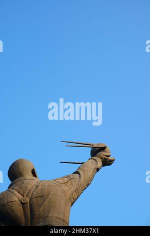 Eine Bronze-Metallstatue eines stehenden Juri Gagarin, des ersten russischen Mannes im Weltraum. Er hält ein Modell des Sputnik-Satelliten. In Taschkent, Usbekistan Stockfoto