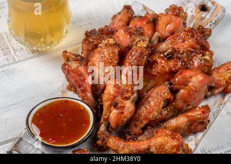 Hähnchenflügel mit Sriracha Sauce auf Holztisch Stockfoto