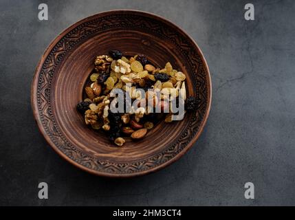 Nüsse und Rosinen in einer Schüssel. Trail-Mix. Essbar, roh, biologisch und vegan. Draufsicht. Speicherplatz kopieren Stockfoto