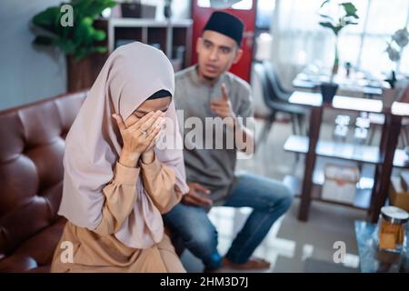 muslimischer wütender Mann brüllt seine Frau an Stockfoto