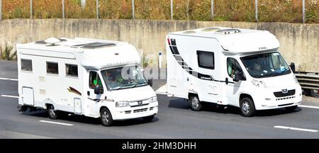 Weißer Wohnmobil überholen Eldiss Autoquest Reisemobil beide Peugeot Seite & Vorderansicht mit Fahrer & Beifahrer Paare fahren entlang der britischen Autobahn Stockfoto