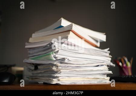 Ein Stapel von Papierblättern und Büchern auf einem Tisch Stockfoto