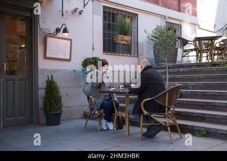 Seniorenpaar. Frau trinkt Tee an einem Tisch auf einer Restaurantterrasse. Stockfoto