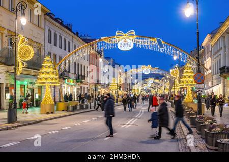 Warschau, Polen - 8. Januar 2022: Menschen in der Neuen Weltstraße (Nowy Swiat), während der Weihnachtszeit für den Verkehr gesperrt, Teil der Königsstraße in der Kappe Stockfoto