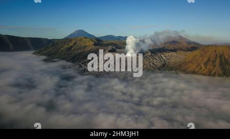 Luftaufnahme des Vulkans Mount Bromo, bedeckt mit dichtem Nebel bei Sonnenaufgang, Surabaya, Java, Indonesien Stockfoto