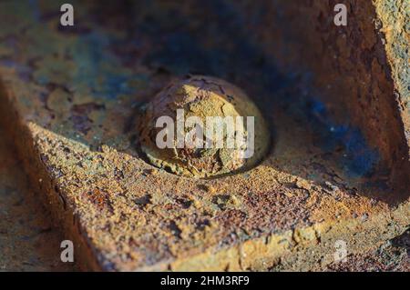 Rostiger Metallniet auf einem alten Stahlträger eines Eisenbahnwagens. Nahaufnahme, Weichfokus. Stockfoto