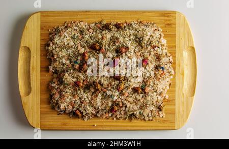 Badesalz mit getrocknetem Lavendel und Rosenblüten. Salzhintergrund für Spa-Behandlungen. Salz auf einem Holzbrett auf weißem Hintergrund. Stockfoto