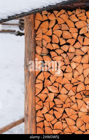 Brennholz im Winter gestapelt. Stapel von Holzstämmen. Natürliches Holz im Dorf, Nahaufnahme von gehacktem Brennholz. Stockfoto