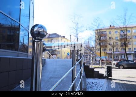 Geländer aus Glas und Edelstahl. Treppe im modernen Interieur. Glasgeländer. Niedriger Winkel Blick auf Treppen, die in Richtung eines modernen Gebäudes führen. Stockfoto
