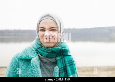 Eine Frau, die in Blau gekleidet ist und Gesichter macht Stockfoto