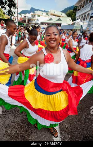 Junge Dame, die während des Karnevals auf den Seychellen auf der Straße tanzt. Stockfoto