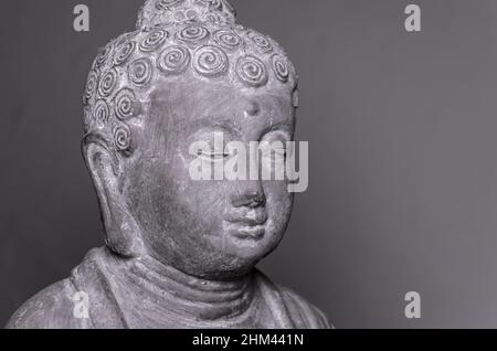 Siddharha Gautama Buddha Statue aus grauem Stein als Innendekoration, Nahaufnahme Portrait Ansicht Stockfoto