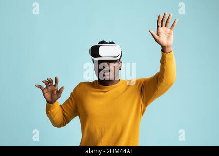 Emotionaler junger afroamerikanischer Mann mit VR-Brille Stockfoto