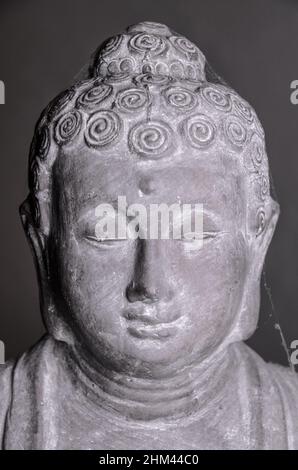 Siddharha Gautama Buddha Statue aus grauem Stein als Innendekoration, Nahaufnahme Portrait Ansicht Stockfoto