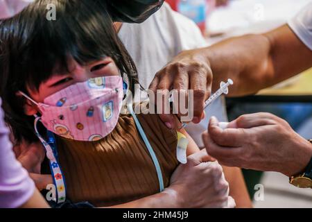 Quezon City. 7th. Februar 2022. Ein Mädchen erhält am ersten Tag der Impfung für Kinder im Alter von 5 bis 11 Jahren in einem Einkaufszentrum in Quezon City, Philippinen, eine Dosis COVID-19-Impfstoff. 7. Februar 2022. Das philippinische Gesundheitsministerium (DOH) meldete am Montag 6.835 neue COVID-19-Infektionen, was die Zahl der bestätigten Fälle im südostasiatischen Land auf 3.616.387 hochdrückte. Die Philippinen starteten am Montag die Impfkampagne gegen COVID-19 für Kinder im Alter von 5 bis 11 Jahren. Quelle: Xinhua/Alamy Live News Stockfoto