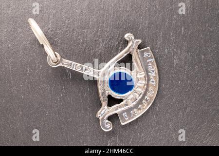 Eine silberne All-Seeing Eye-Pendelleuchte auf Schieferstein, Makro, Draufsicht. Stockfoto