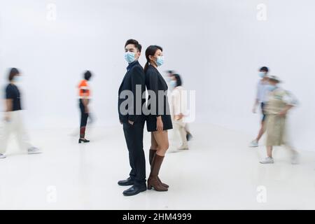 Geschäftsleute trugen Masken, um in der Menge zu stehen Stockfoto