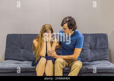 Das junge Paar schwört auf der Couch. Konzept der emotionalen Intelligenz Stockfoto