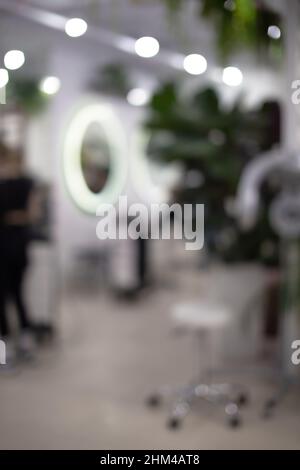 Eleganter Schönheitssalon Friseur Innenraum Hintergrund. Defokussiertes modernes Friseurgeschäft Stockfoto