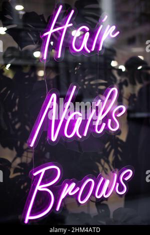 Schönheitssalon Neon Zeichen Haare, Nägel, Brauen. Friseursalon, Maniküre Schrank, Augenbrauen Korrektur. Geringe Schärfentiefe Stockfoto