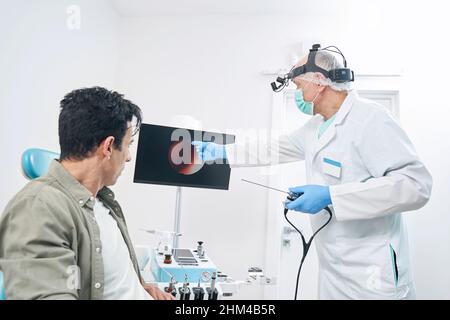 Arzt erzählt dem Menschen nach der Untersuchung seiner Gesundheit von einem Bild Stockfoto