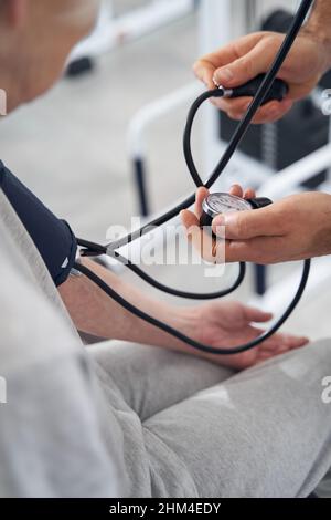 Der Arzt überprüft die Werte am Blutdruck-Monitor Stockfoto