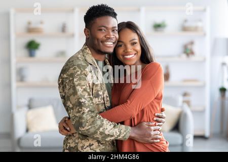 Glückliche Afroamerikanische Familie Militär Ehemann Und Ehefrau Umarmen Zu Hause Stockfoto
