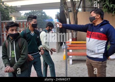 Neu-Delhi, Indien. 07th. Februar 2022. Die Schüler erhalten eine Temperaturprüfung und tragen Masken in den Klassenzimmern als Teil der Covid-19-Vorsichtsmaßnahmen während der Wiedereröffnung der höheren Sekundarstufen, da einige Schulen am 7. Februar 2022 vom Education Board of Delhi in Delhi, Indien, wieder eröffnet wurden. (Foto: Ravi Batra/Sipa USA) Quelle: SIPA USA/Alamy Live News Stockfoto