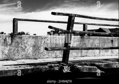 Beschädigte und verbogene Leitplanke entlang der Kante einer Brücke, die repariert werden muss. Stockfoto